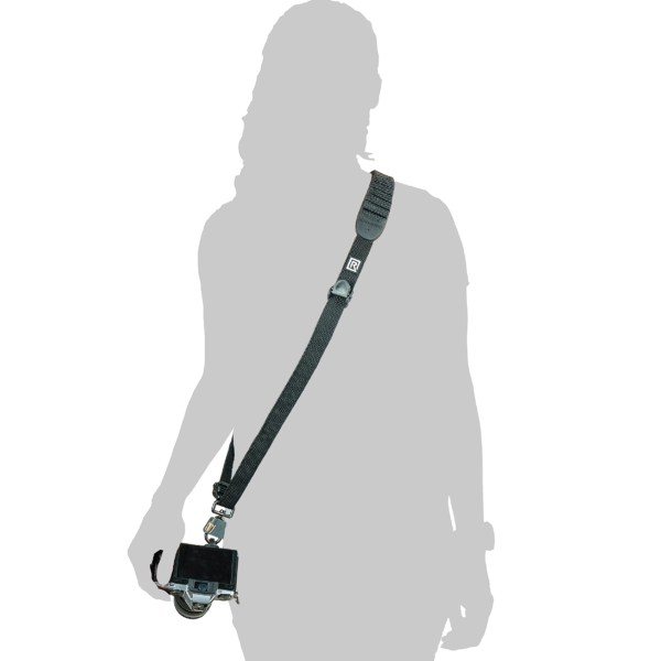 A woman holds a BlackRapid camera sling strap with a camera attached, designed for outdoor photographers on the go.