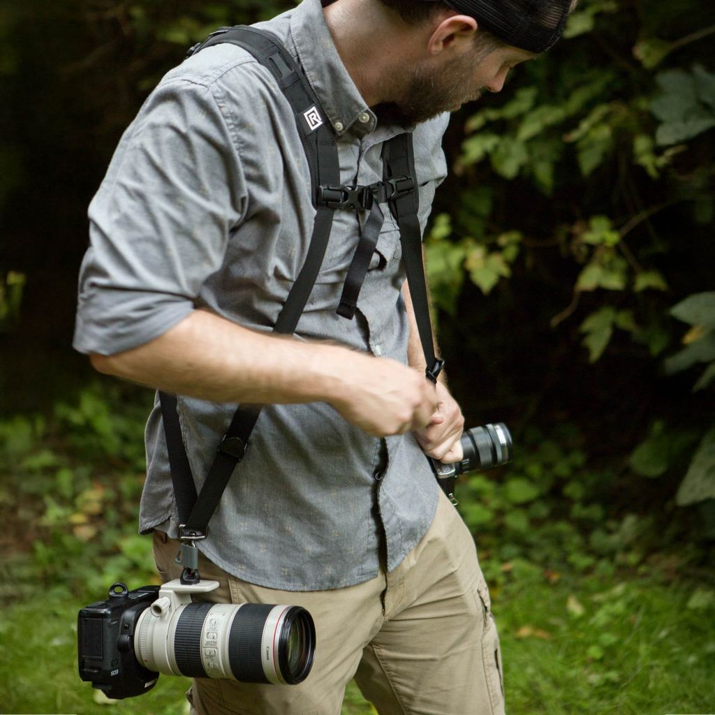 photographer carrying blackrapid strap with zoom lens